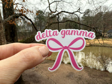 Load image into Gallery viewer, Sticker | DG | Delta Gamma Pink Bow | Waterproof Vinyl Sticker | White | Clear | Permanent | Removable | Window Cling | Glitter | Holographic