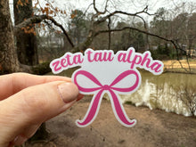 Load image into Gallery viewer, Sticker | ZTA | Zeta Tau Alpha Pink Bow | Waterproof Vinyl Sticker | White | Clear | Permanent | Removable | Window Cling | Glitter | Holographic