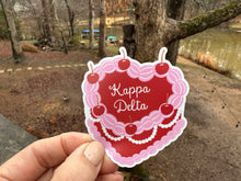 Load image into Gallery viewer, Sticker | KD_C | Kappa Delta Heart Shaped Cake | Waterproof Vinyl Sticker | White | Clear | Permanent | Removable | Window Cling | Glitter | Holographic