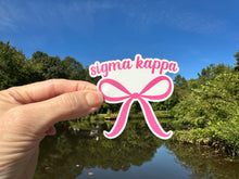 Load image into Gallery viewer, Sticker | SK | Sigma Kappa Pink Bow | Waterproof Vinyl Sticker | White | Clear | Permanent | Removable | Window Cling | Glitter | Holographic (Copy)