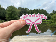 Load image into Gallery viewer, Sticker | AXID | Alpha Xi Delta Pink Bow | Waterproof Vinyl Sticker | White | Clear | Permanent | Removable | Window Cling | Glitter | Holographic